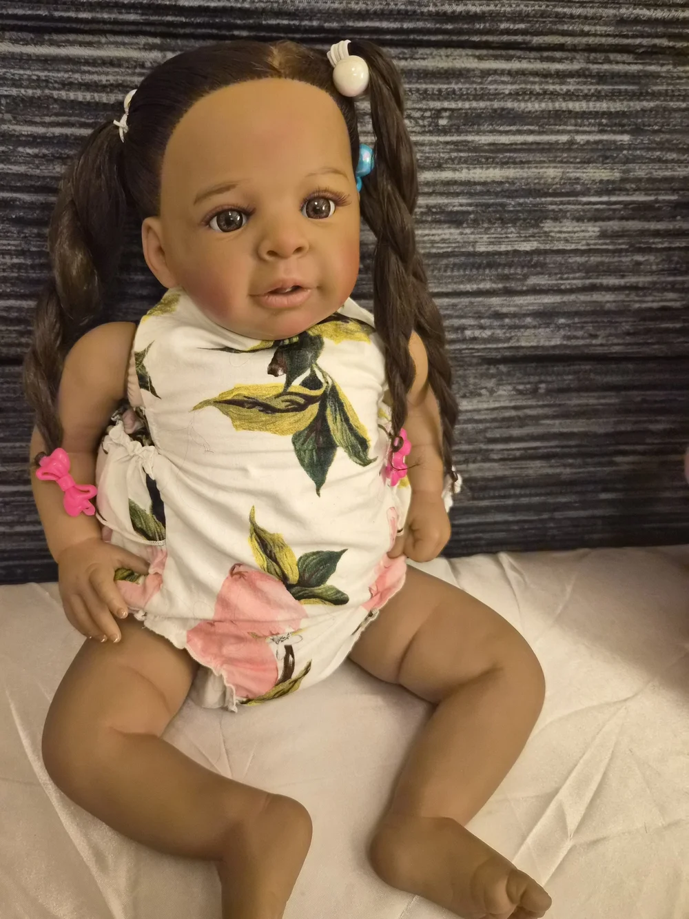 Reborn brown baby doll with pink and white floral outfit